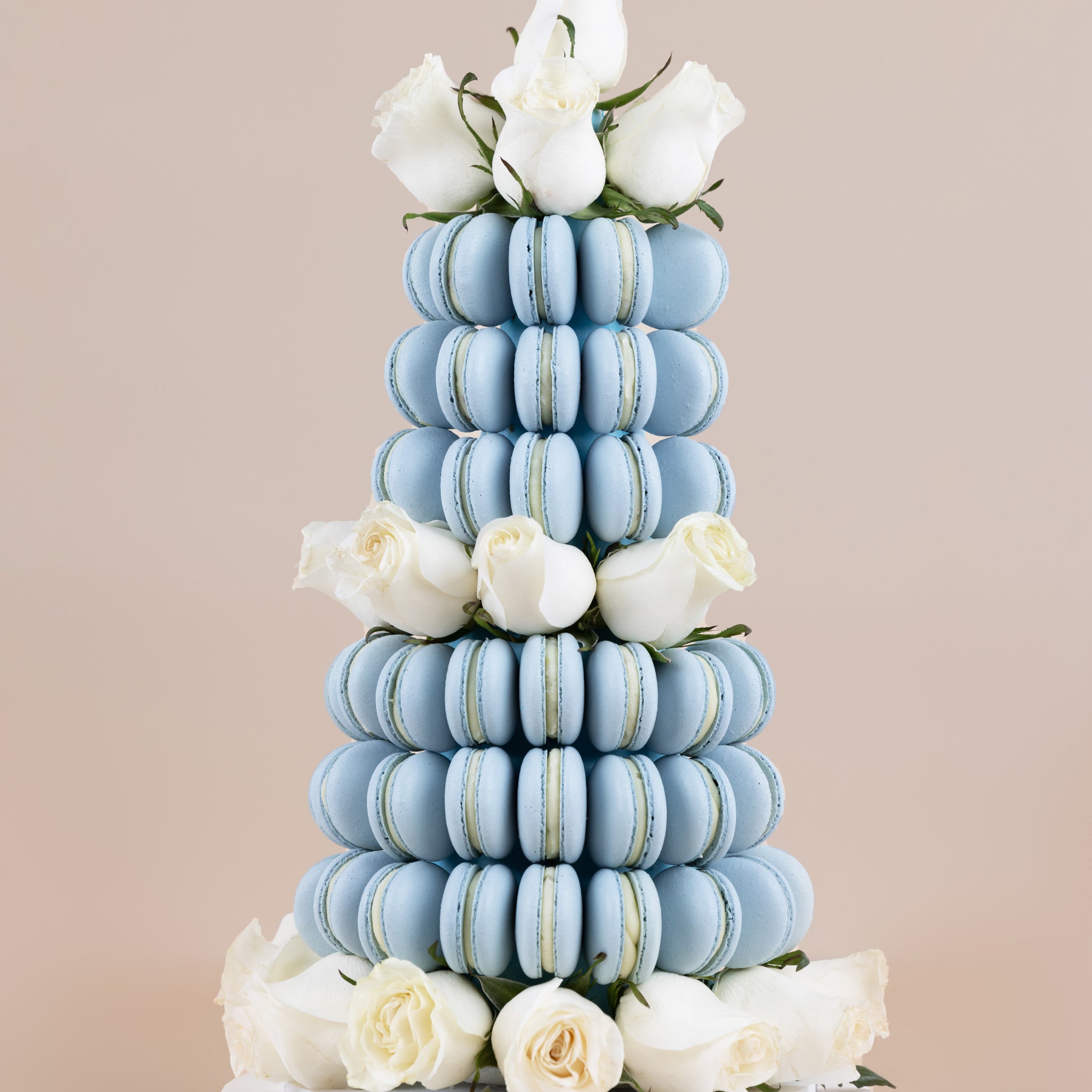 A Baby Blue themed macaron tower adorned with fresh, white Colombian roses that can be made in small, medium or large