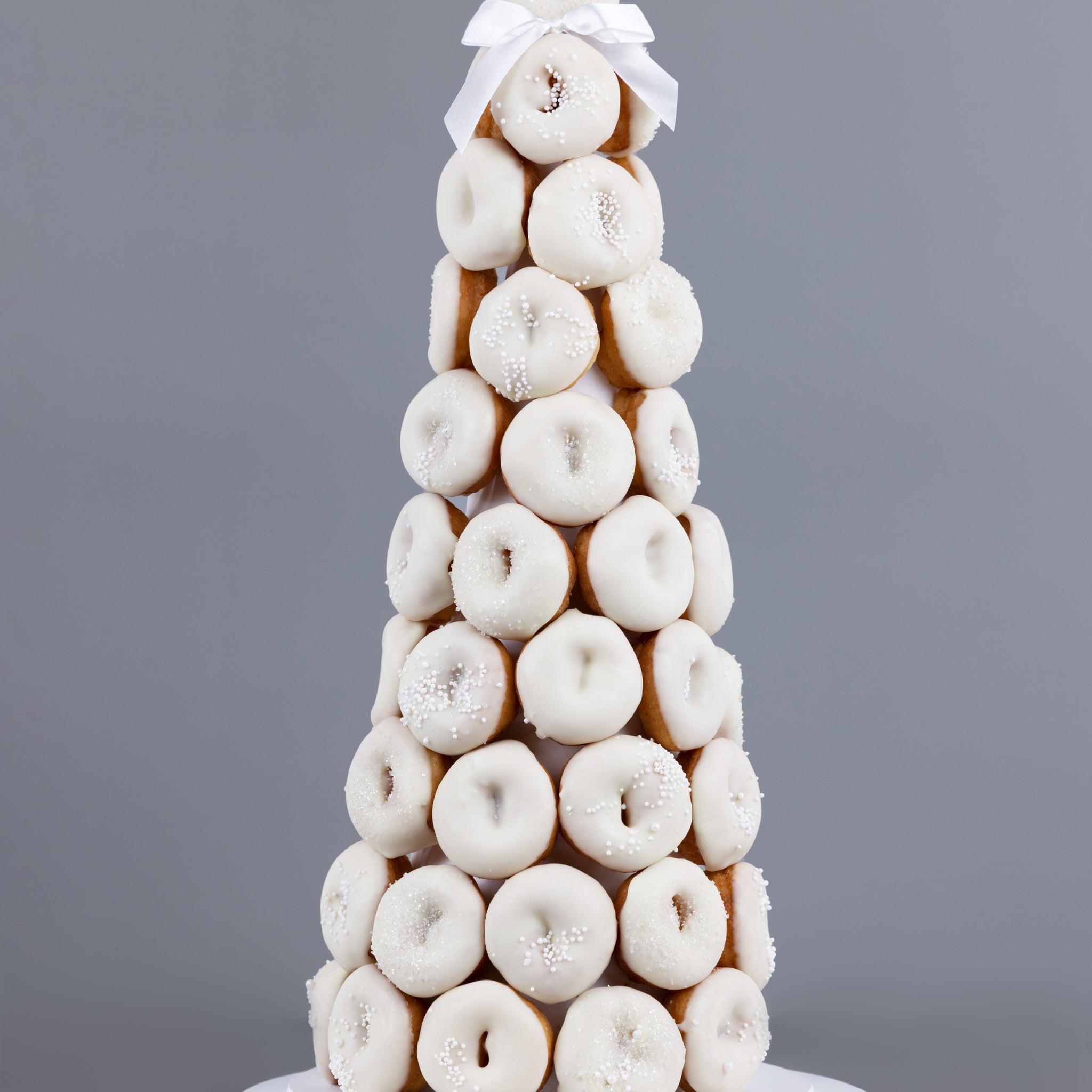 White themed doughnut tower made from premium chocolate coated doughnuts with a designer sprinkle arrangement