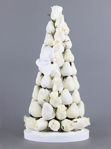 Tower made of white, chocolate dipped strawberries with white Colombian roses placed within and at the base of the tower and an orchid